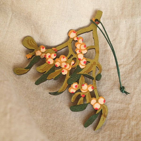 Decorative mistletoe ornament on a textured beige background