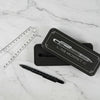 Pencil case labeled 'The Architect' with a pen and ruler on a dark background