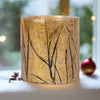 Decorative glass candle holder with leaf pattern on a white background