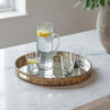 Tray with a pitcher and glasses of water with lemon slices on a wooden table.