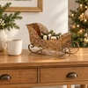 Compact 31 cm Noel gold filigree sleigh with miniature presents beside a coffee mug on an oak console