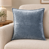 Sorella indigo stonewashed cotton velvet cushion on an oatmeal armchair