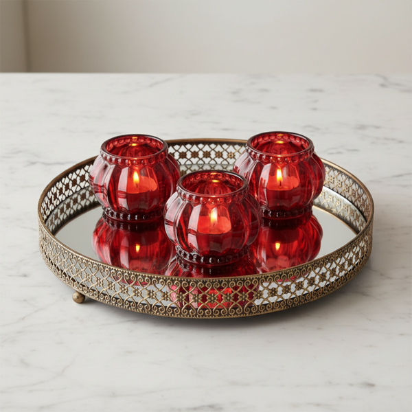 Styled product image of antique gold mirrored tray with lit ruby votives