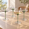 Varenna Green Stem Coupe Glasses Set of Four on a pale oak table